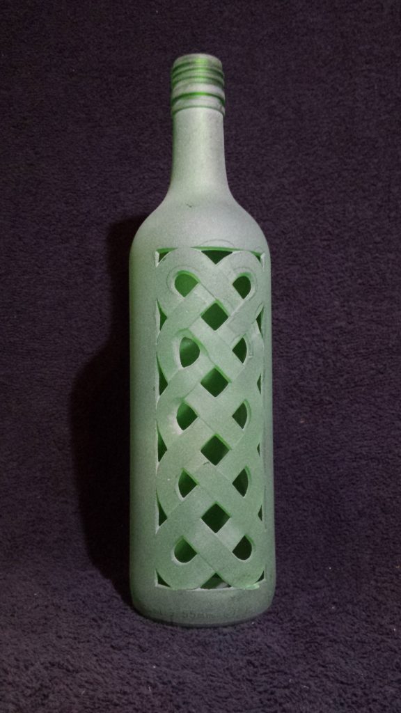 A green frosted with a celtic knotwork design carved through the glass