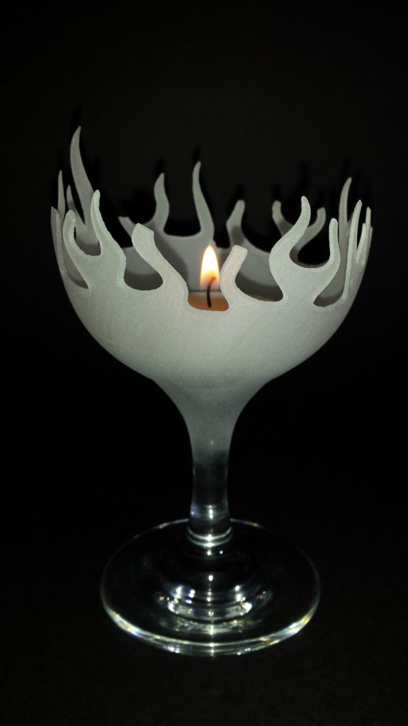 The hot glass holding a lit candle